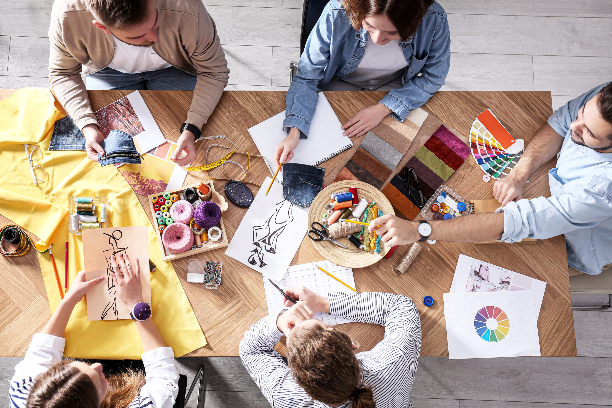 Fashion designer creating new clothes in studio, top view